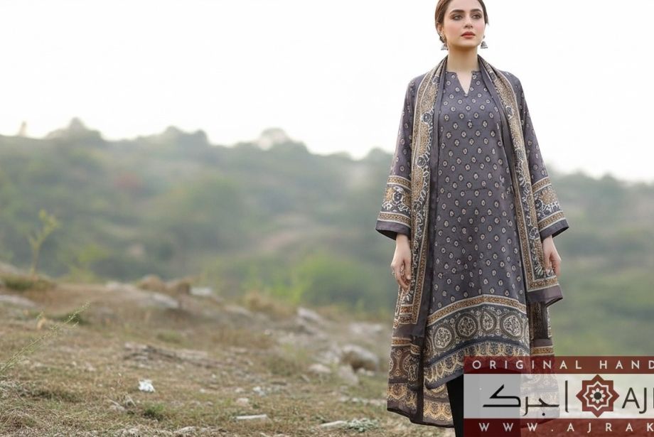 Model wearing handmade grey Ajrak silk 2-piece suit with golden motifs and elegant border.